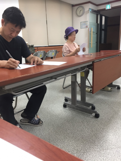 Participants writing their farewell letters during the coffin therapy, a guided death meditation, in Seoul