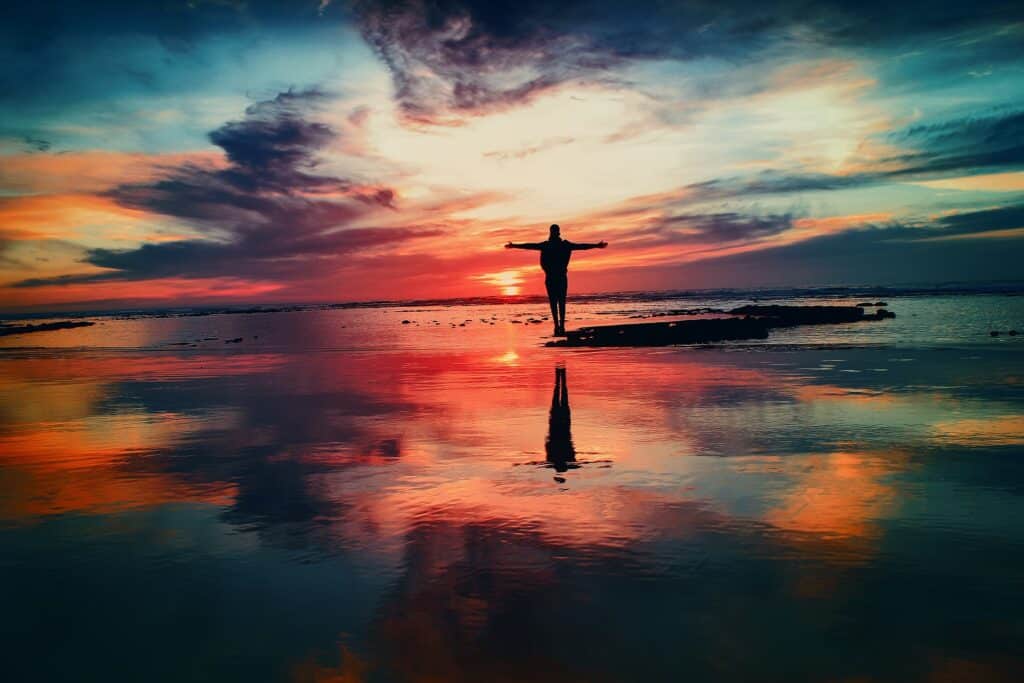 A lone silhouette on still water at sunset, time without a clock