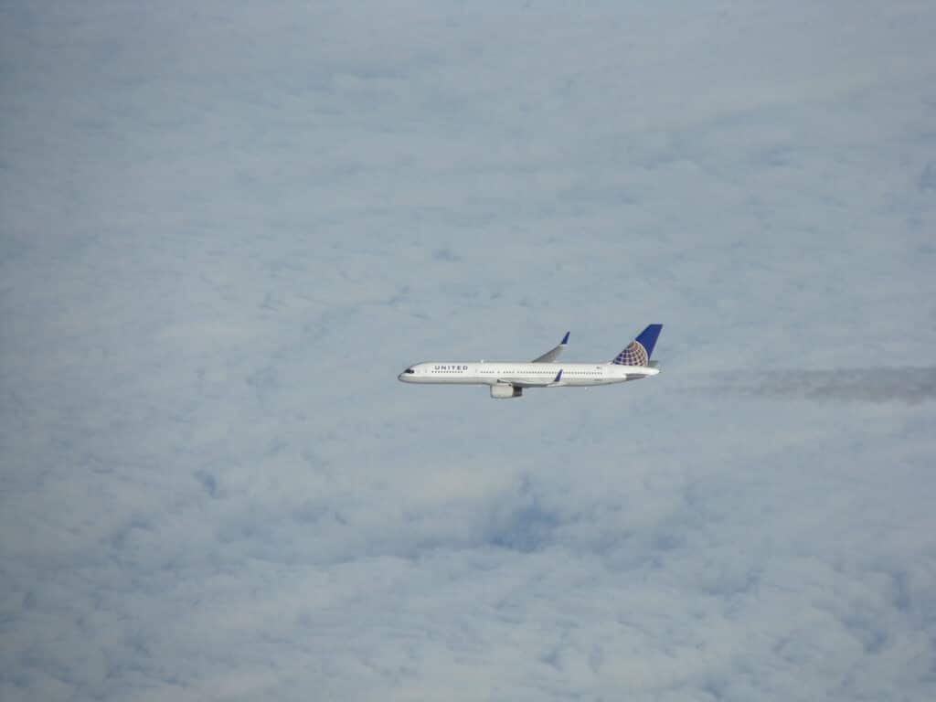A Boeing 757 seen from above, over the clouds