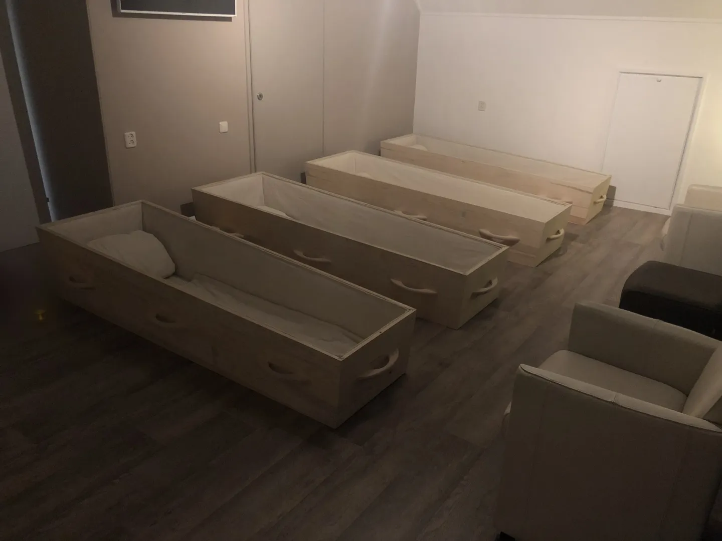 Open wooden coffins with pillows, set up for the participants in a memento mori coffin meditation